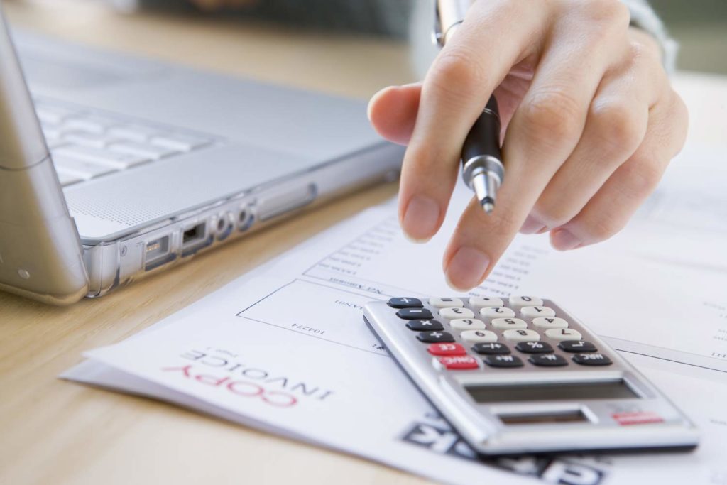 Person using calculator to understand cost of dental implants