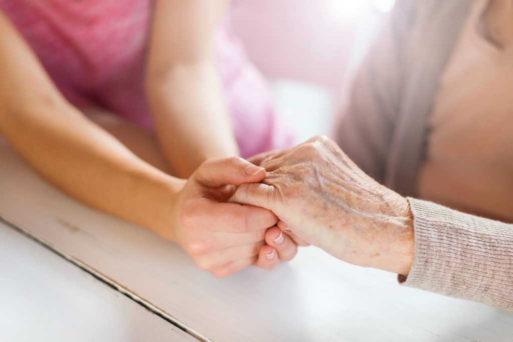 elderly parent holding hands